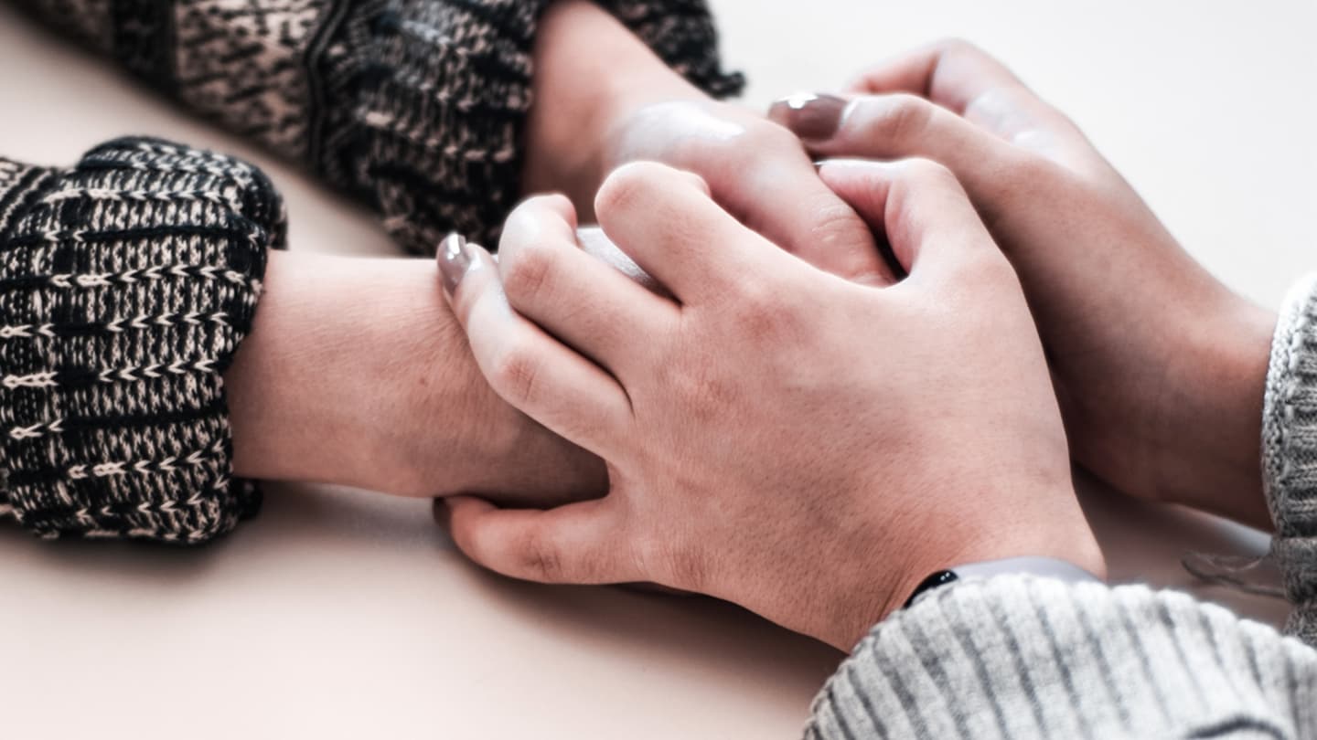 Closeup photograph of two people with joined hands